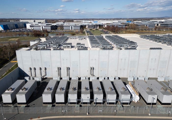 Uma vista aérea mostra ventiladores de resfriamento no telhado próximo a geradores no nível inferior de um data center